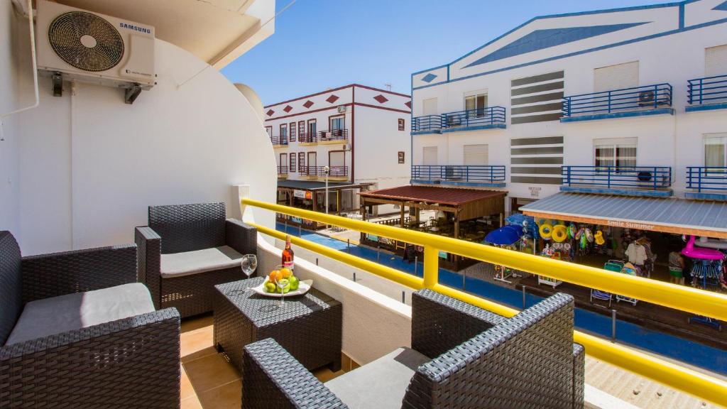 阿尔图拉Apartamento T2 na Praia da Alagoa的一个带桌椅的阳台和一个游泳池