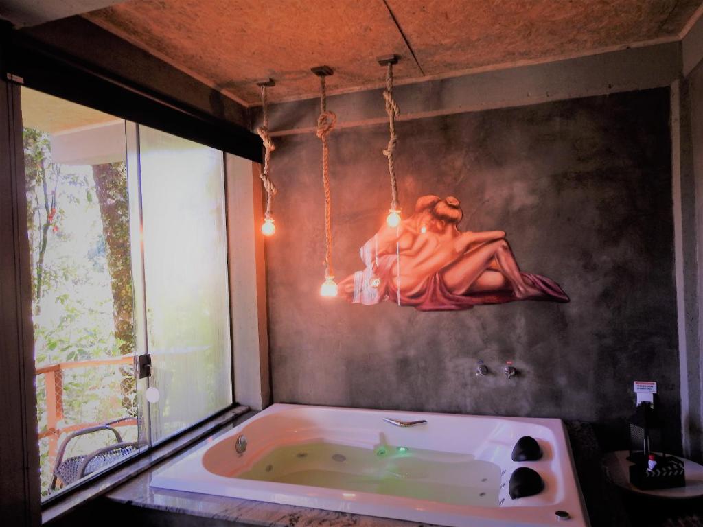 蒙特韦尔迪Recanto Lira I的带浴缸的浴室,墙上有女士