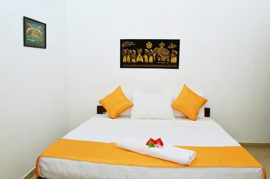 阿努拉德普勒Villa DeLorenta的卧室配有带橙色枕头的白色床