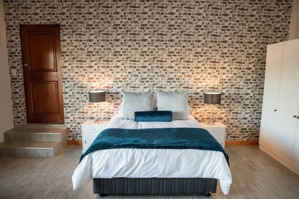 帕尔Sol Montis Guest Cottage的一间卧室设有一张床和砖墙