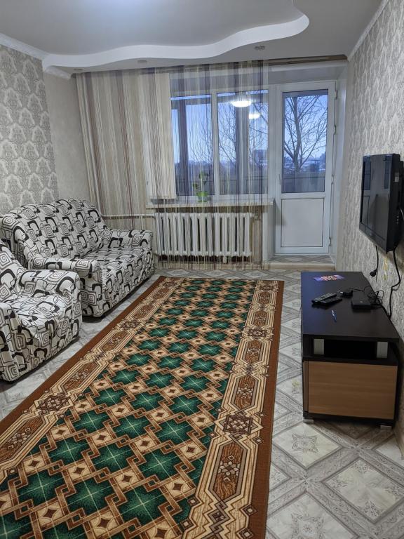休钦斯克Квартира в районе жд вокзала的带沙发和地毯的客厅