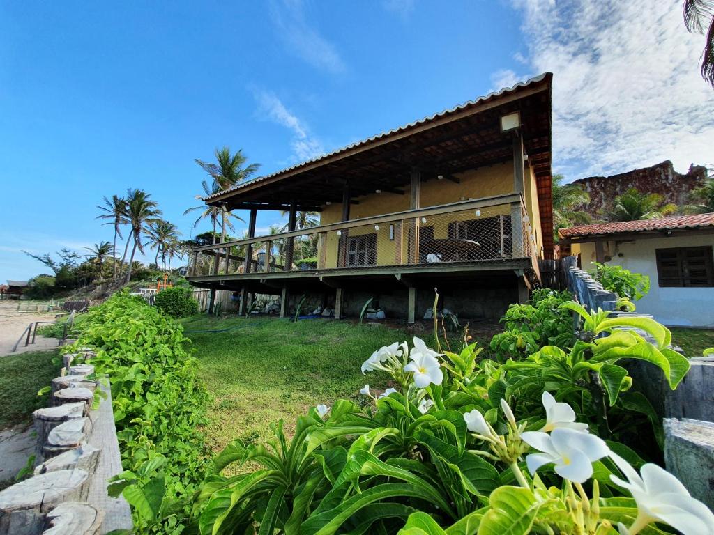 伊卡普伊Casa na Beira do Mar, Peroba, Icapuí/CE, Morada Mariana的海滩上的房子,前面有鲜花