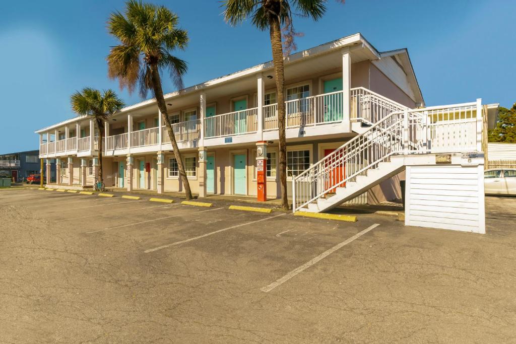 默特尔比奇OYO Hotel Myrtle Beach Kings Hwy的停车场内棕榈树的建筑