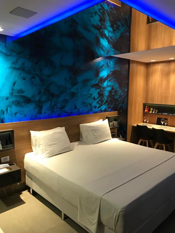 萨尔瓦多Fantasy Motel的一间卧室设有一张蓝色天花板的大床