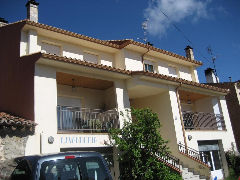 拉斯卡弗里亚拉斯卡弗里亚萨其拉公寓的前面有一辆汽车停放的白色房子