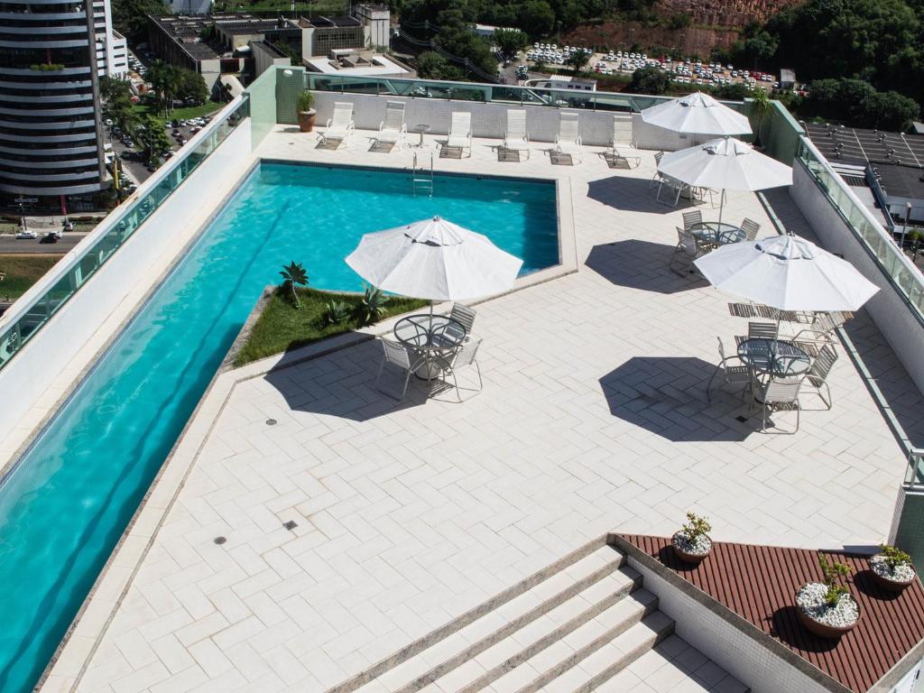 萨尔瓦多Iguatemi Business & Flat by Avectur的享有带遮阳伞的游泳池的顶部景致