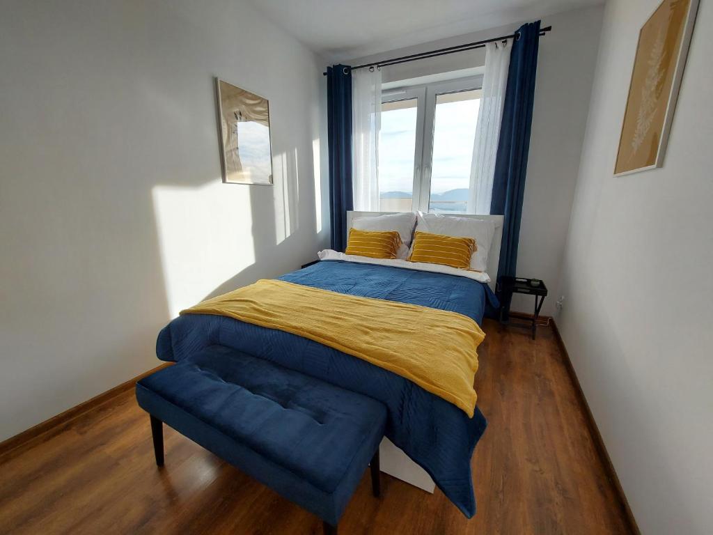 耶莱尼亚古拉Allewidok的一间卧室配有一张带蓝色毯子的床和窗户。