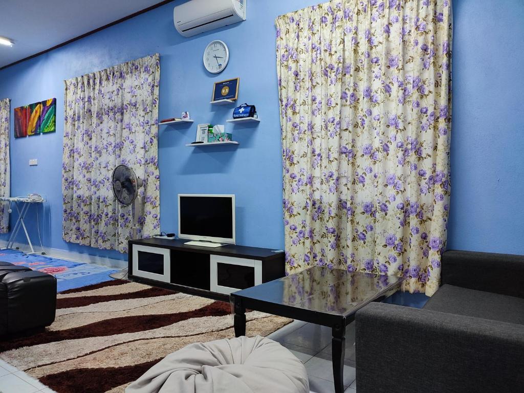 Rantau PanjangRiverview Homestay - Homestay Tepi Sungai Golok的客厅设有蓝色的墙壁、窗帘和电视。