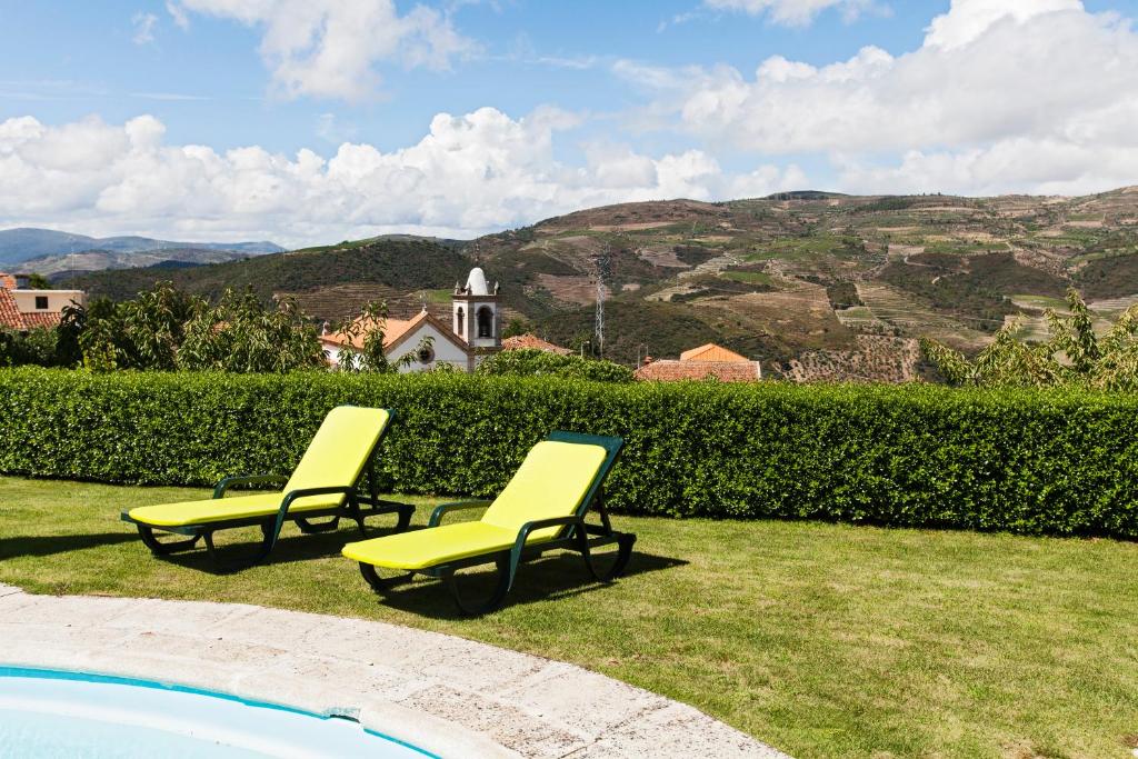 塔布阿苏Douro House Loft的两把黄色椅子坐在游泳池旁