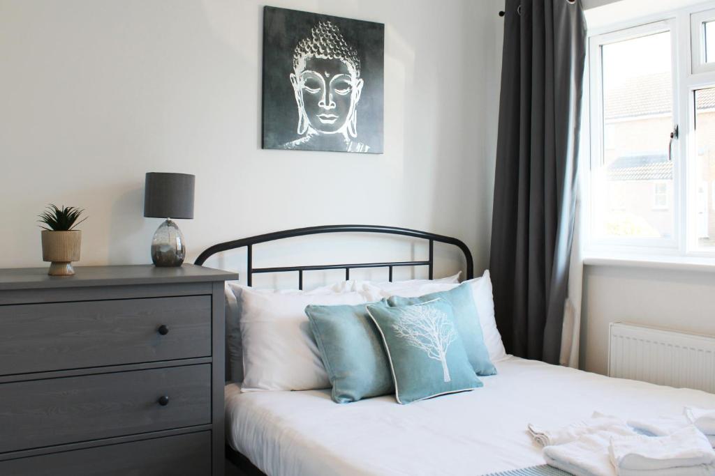 阿宾登Abingdon - Private Flat with Garden & Parking 06的一间卧室配有一张带蓝色和白色枕头的床