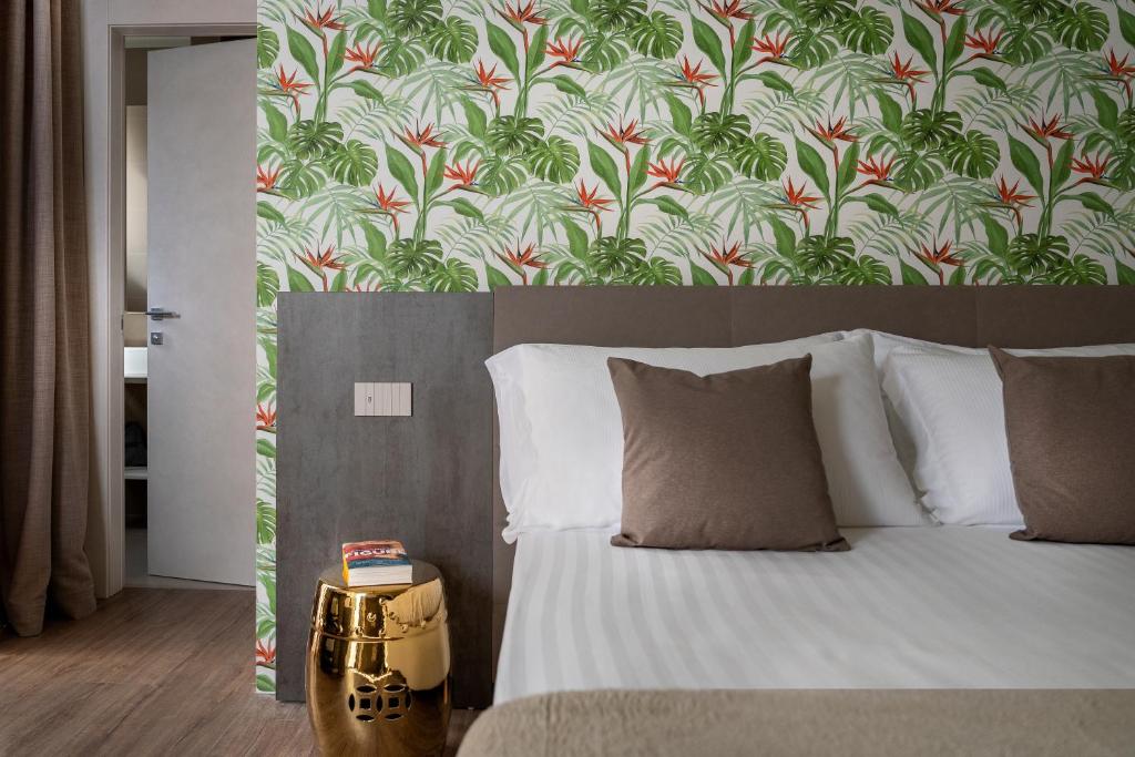 加比切马莱Civico25 Suite Hotel的一间卧室配有一张带花卉壁纸的床