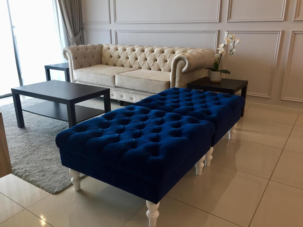 莎阿南Lodge Alpha LaVista at Emira Residence Shah Alam的带沙发和蓝色搁脚凳的客厅