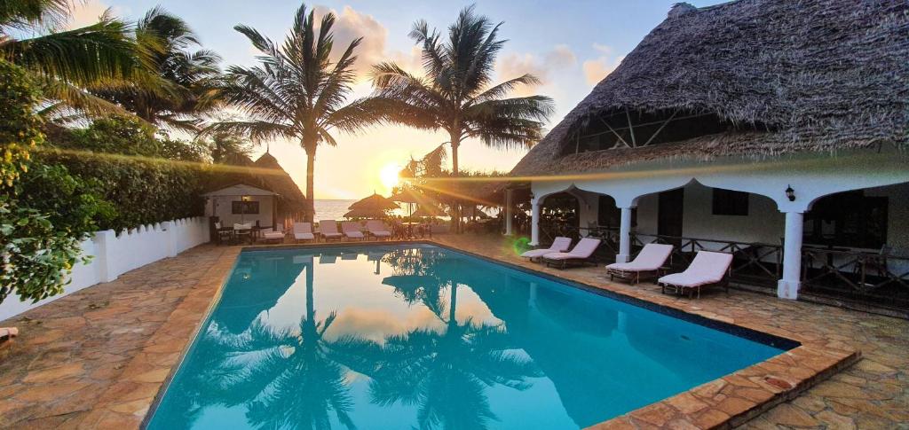 马特姆维桑给巴尔度假酒店 的一座别墅,设有游泳池和棕榈树