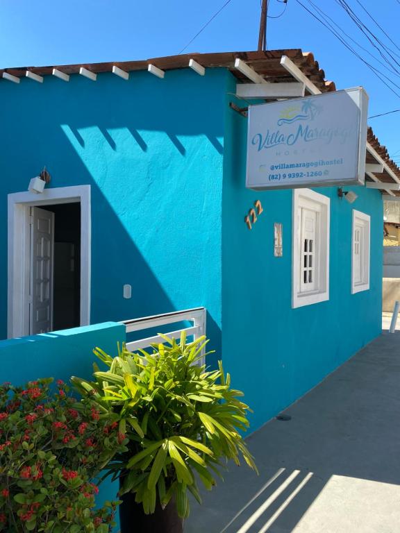马拉戈日Villa Maragogi Hostel的蓝色的建筑,上面有标志