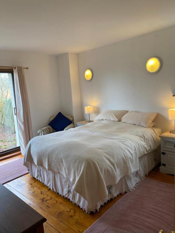 LasswadeGorton House and Cottages的卧室设有一张白色大床和一扇窗户。