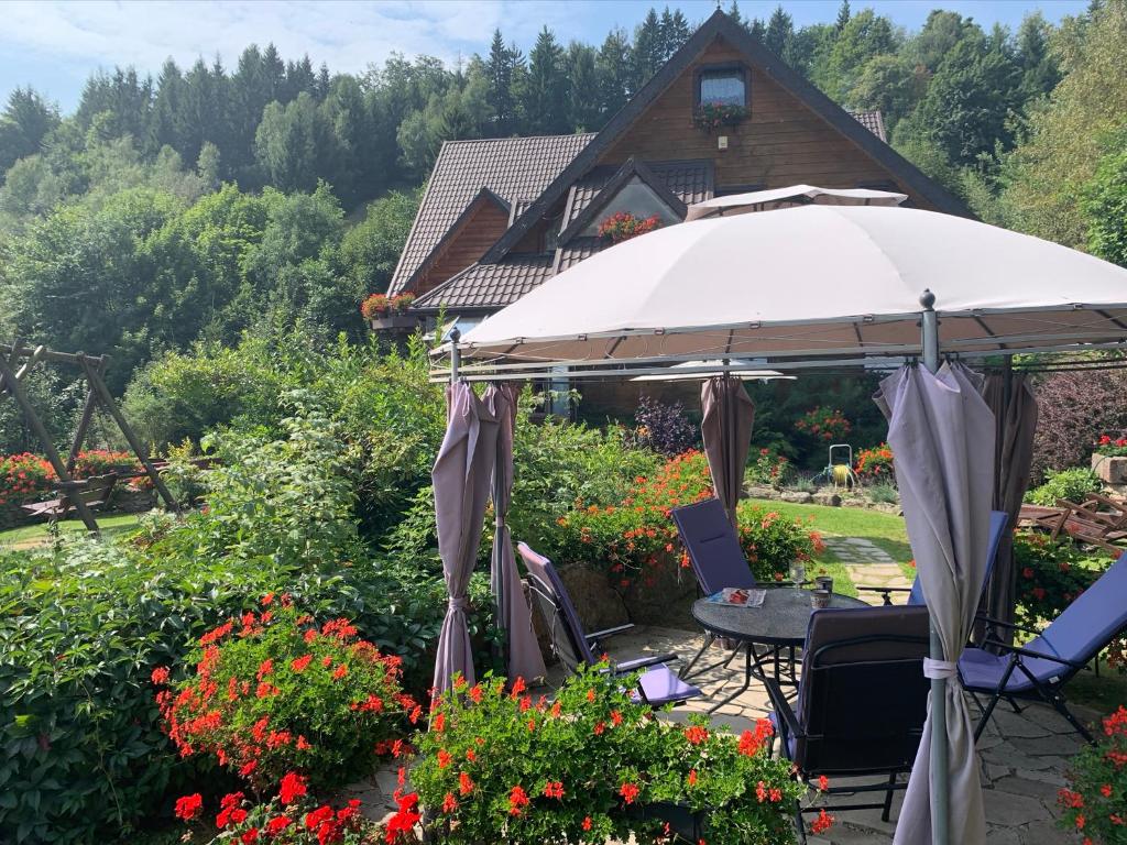 索克莱克Agropajda的一个带遮阳伞、椅子和鲜花的庭院