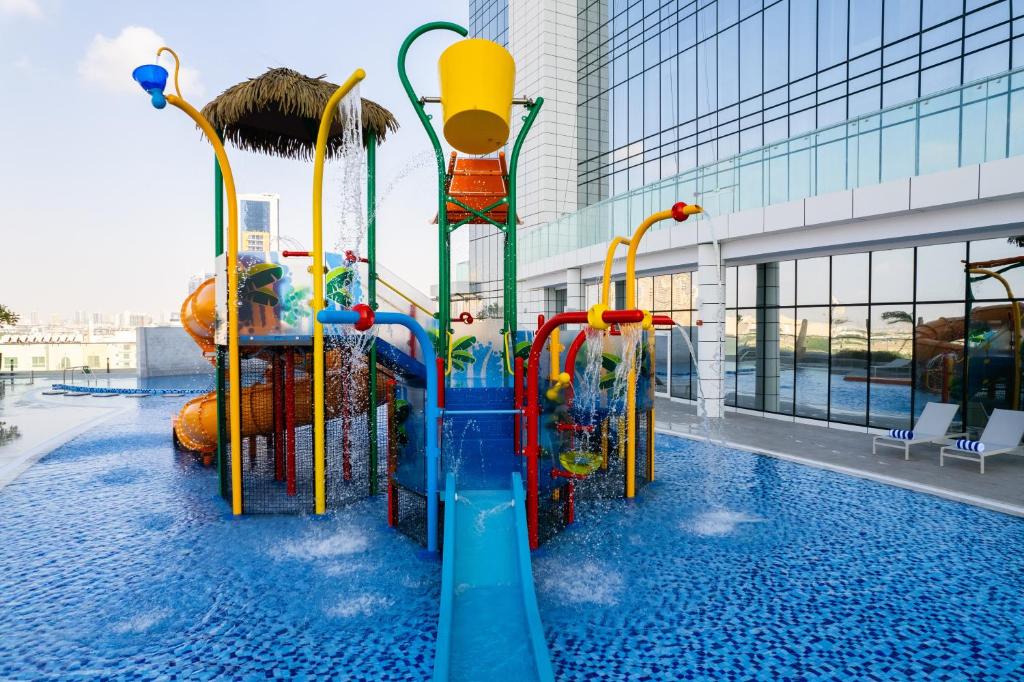 迪拜Novotel Jumeirah Village Triangle的大楼游泳池的水滑梯