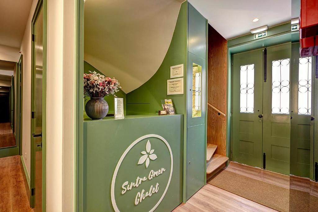 辛特拉Sintra Green Chalet Bed & Breakfast的一条带绿门的走廊,花瓶