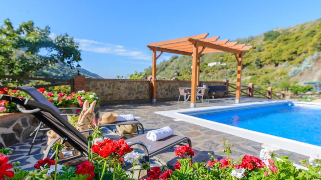 内尔哈Villa La Cola Nerja by Ruralidays的一个带游泳池和木制凉亭的庭院
