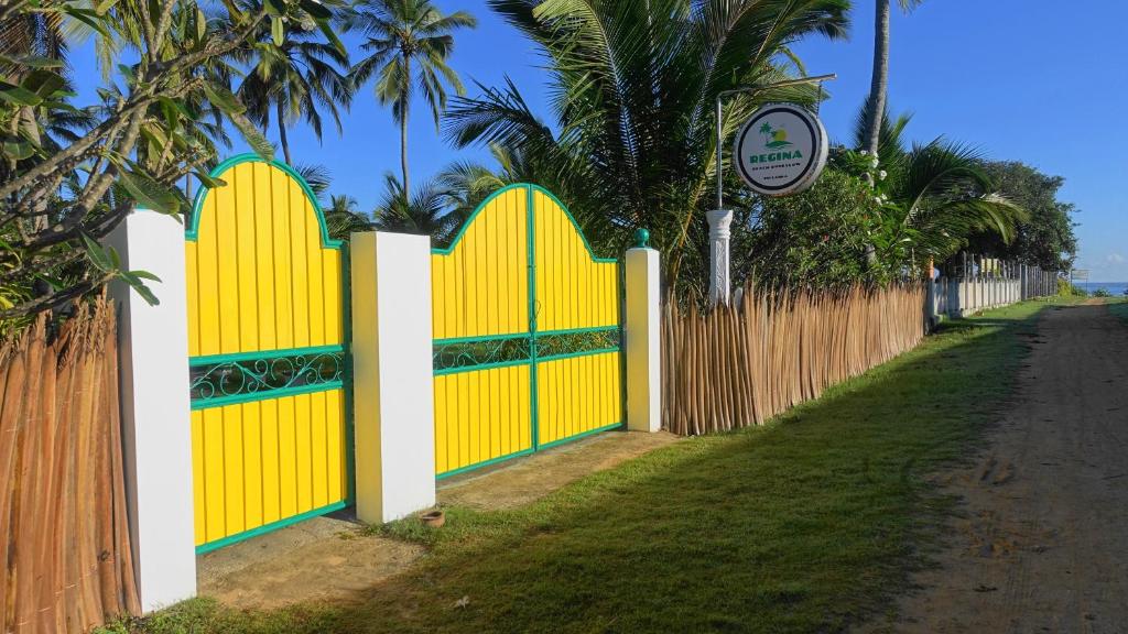 亭可马里Regina Beach Bungalow的路旁有黄色门的栅栏