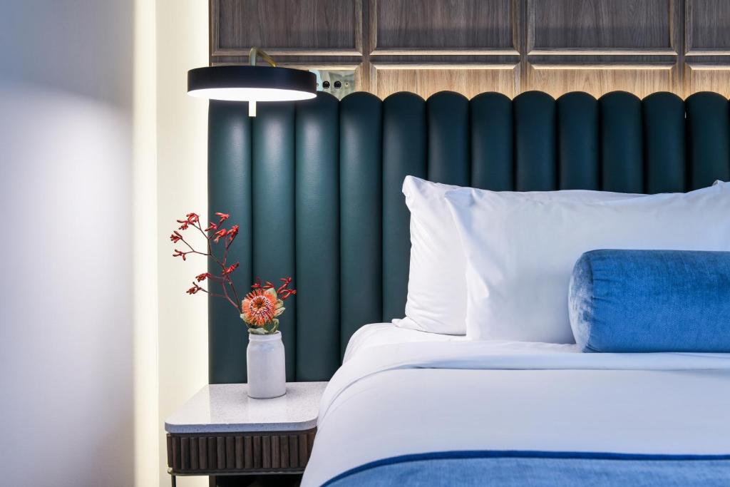 塔姆沃思Powerhouse Hotel Tamworth by Rydges的一间卧室配有一张床和一个绿色床头板