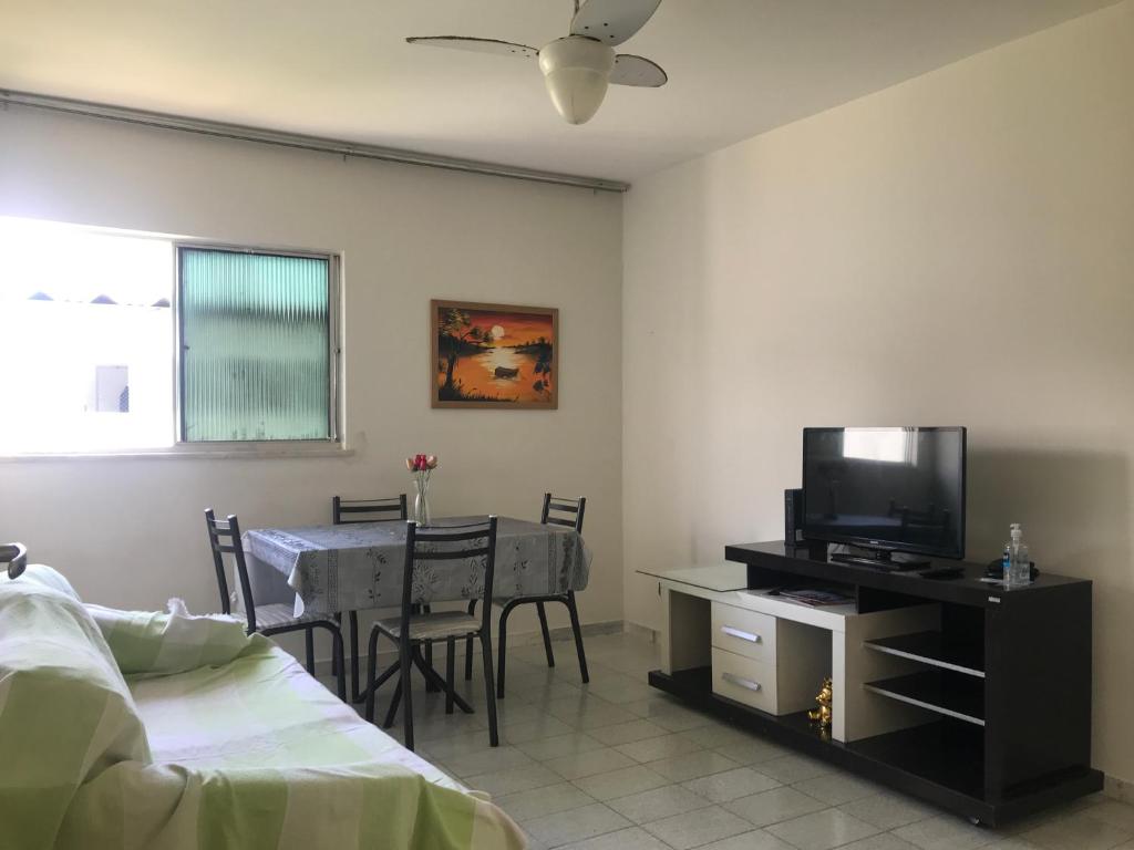 阿拉卡茹Mar Azul Condomínio的客厅配有一张床和一张桌子及一台电视