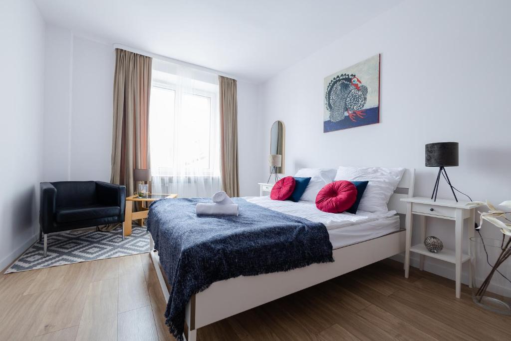 琴斯托霍瓦Pod Skrzydłami - centrum - 24h的一间卧室配有一张带蓝色毯子和椅子的床