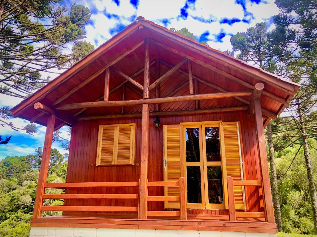 邦雅尔丁-达塞拉Recanto Baú - Chalé的小型木制小屋设有大窗户