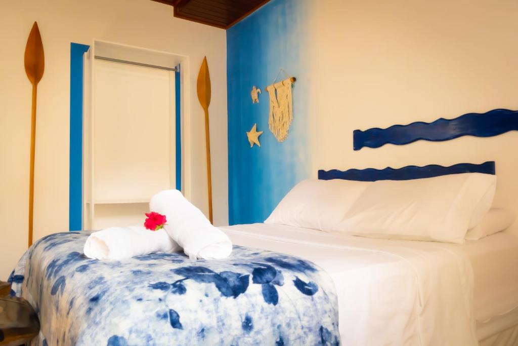 阿布拉奥Raio de Sol pousada & camping的蓝色和白色的卧室,配有带毛巾的床