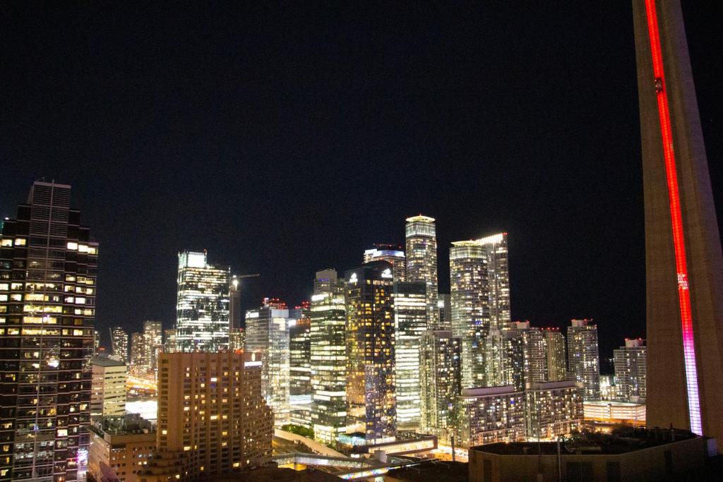 多伦多Downtown High-rise Condo- CN Tower View的享有大城市的夜景,拥有高高的建筑