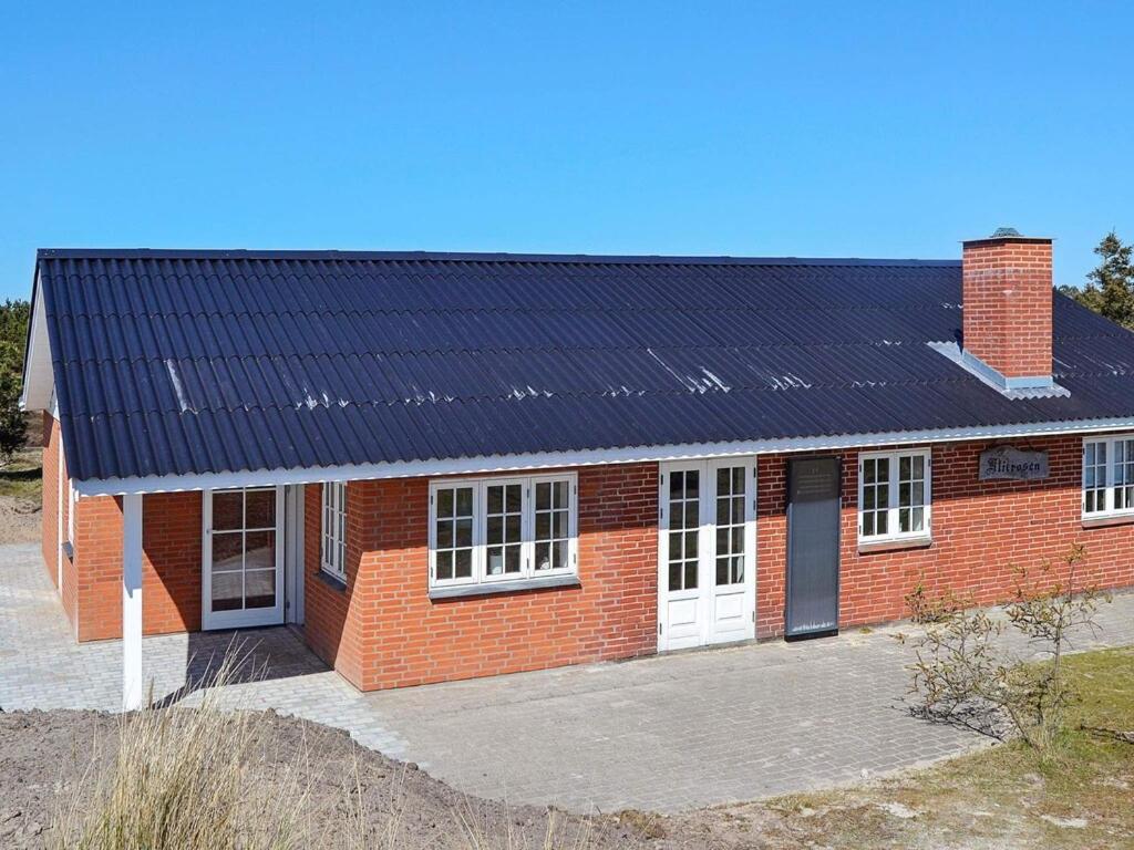 凡岛4 person holiday home in Fan的一座红砖房子,设有太阳能屋顶