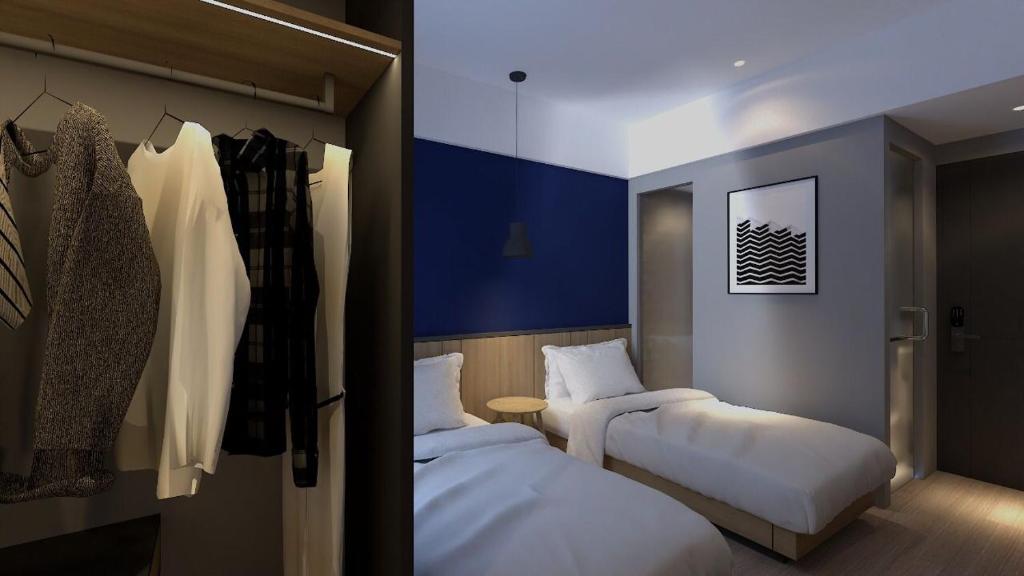 雅加达LeGreen Suite Sudirman的酒店客房设有两张床和一个衣柜。