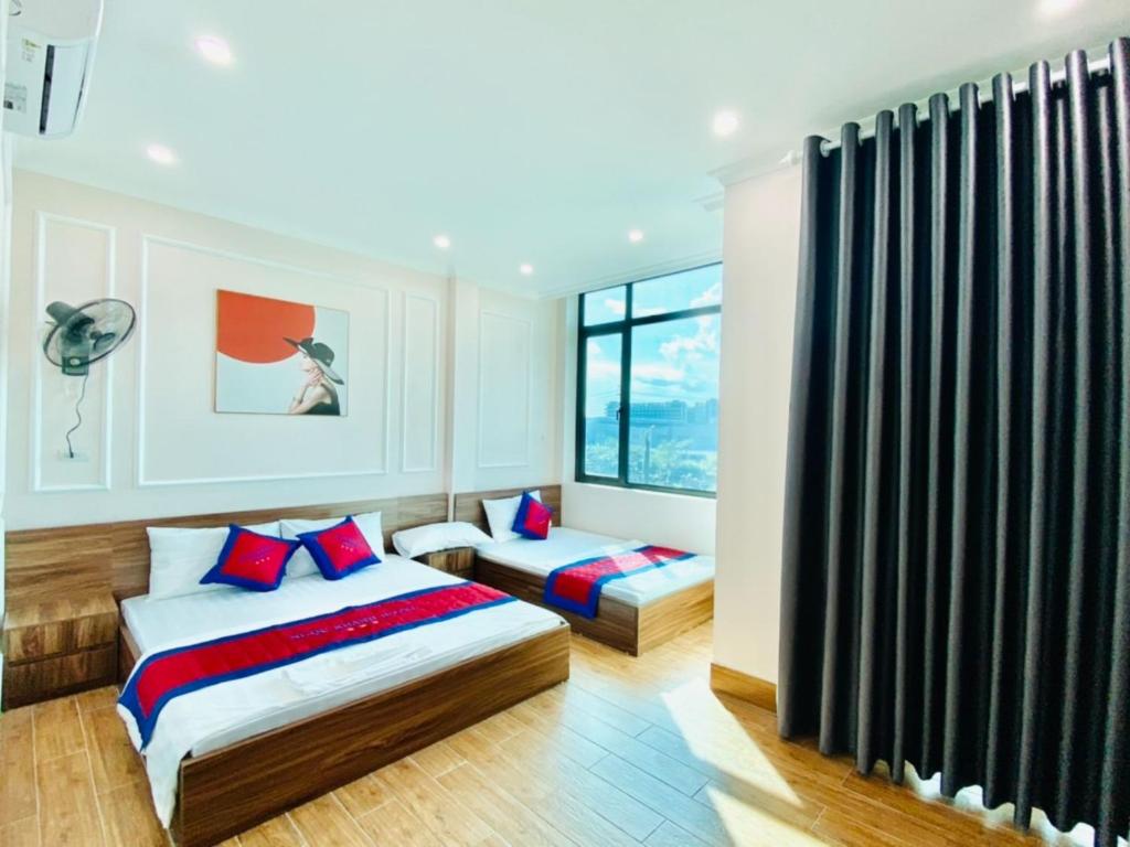 Việt YênNgoc Khanh Hotel的一间卧室设有两张床和窗户。