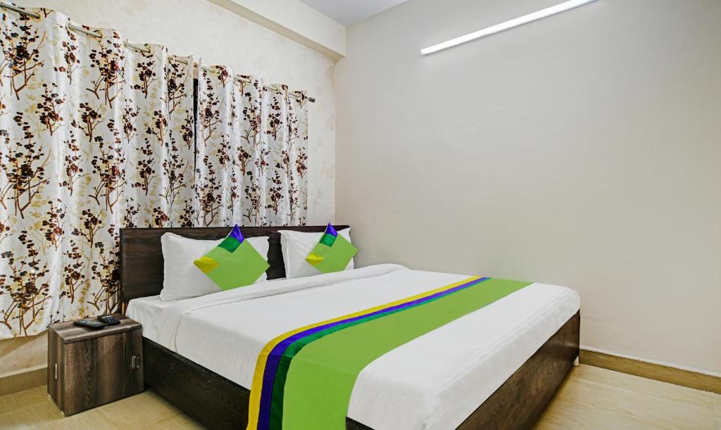 博帕尔Treebo Trend Alankar Hoshangabad Road的一间卧室配有一张带彩色毯子的床