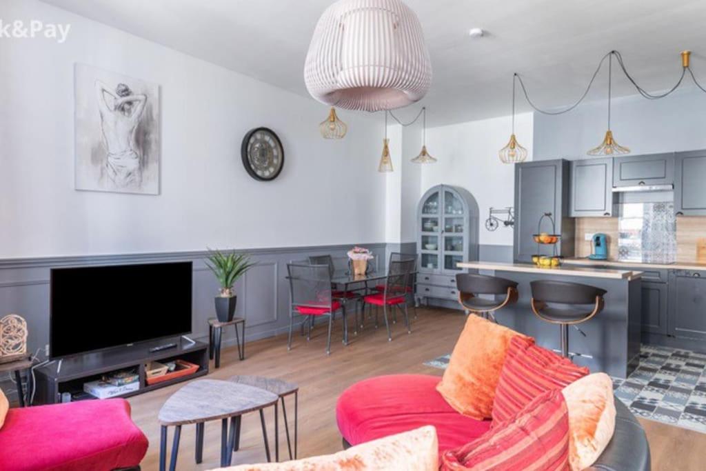 贝济耶Cauquilha SPACIEUX APPARTEMENT BOURGEOIS EN CENTRE VILLE的一间带红色沙发的客厅和一间厨房
