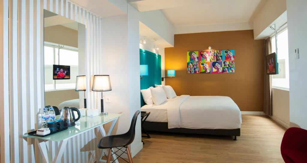 马塔兰龙目岛爱多普酒店的配有一张床和一张书桌的酒店客房