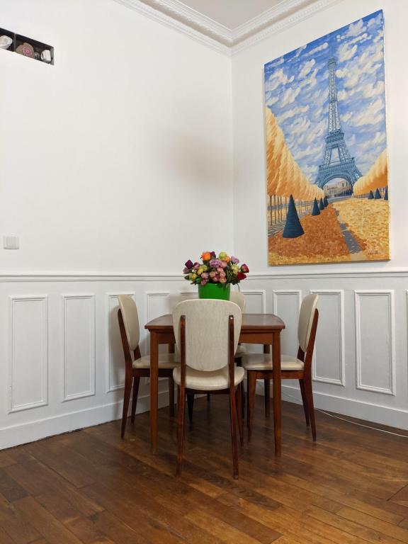 巴黎Private acces to the all flat. Charming Parisian.的一间带桌椅和绘画的用餐室