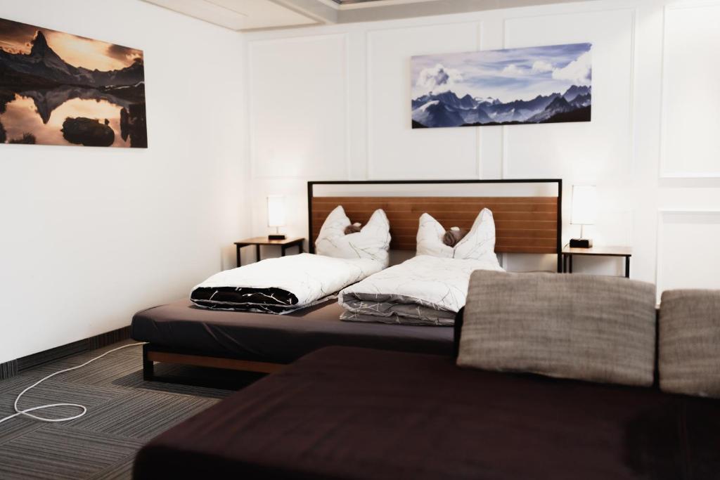 肯普滕Unterkunft KemptenCityHost的一间带两张床和一张沙发的卧室