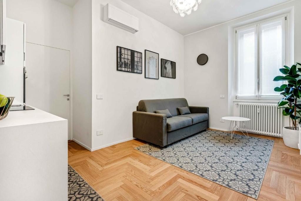 米兰New Milan Central Apartment的客厅配有真皮座椅和桌子