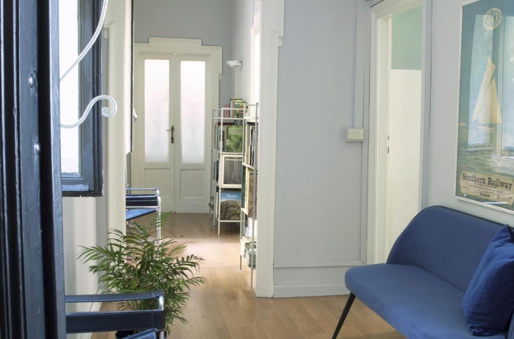 米兰Liberty Two-Room Apartment in Porta Venezia的客厅配有蓝色沙发和植物