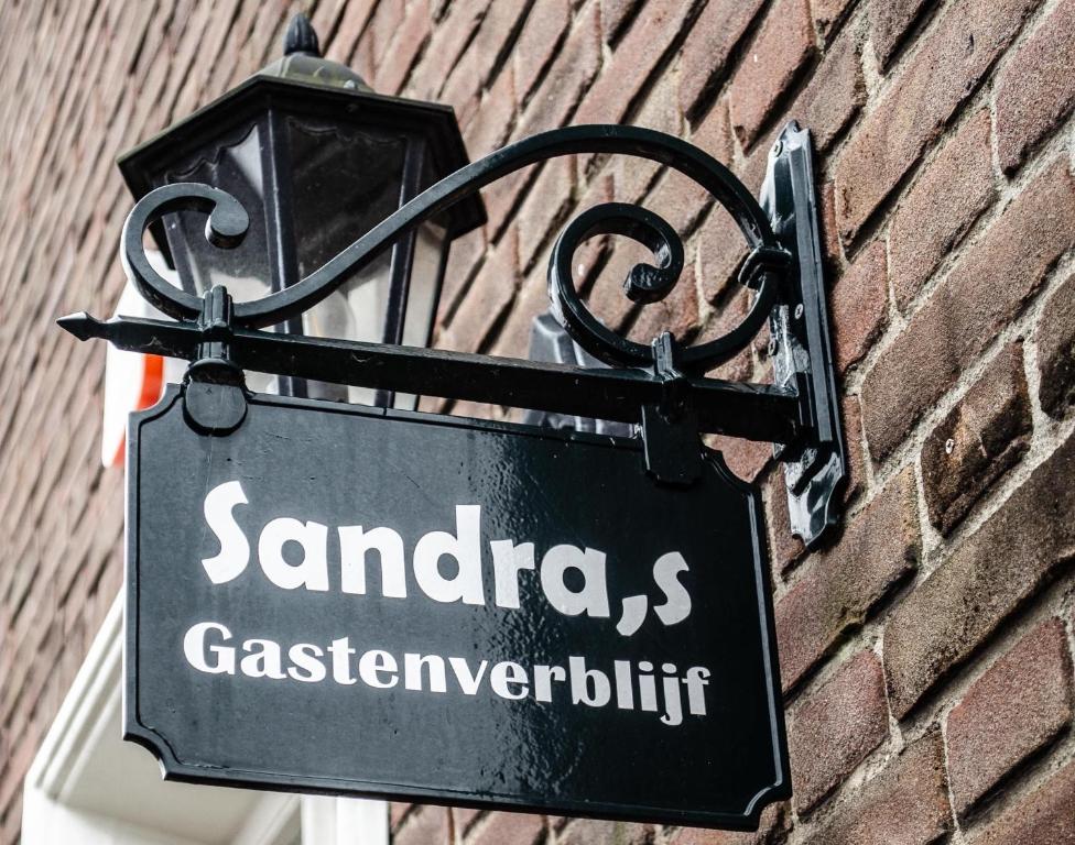 东福尔讷Sandra’s Gastenverblijf的贴在砖墙上的标志,带有街道标志