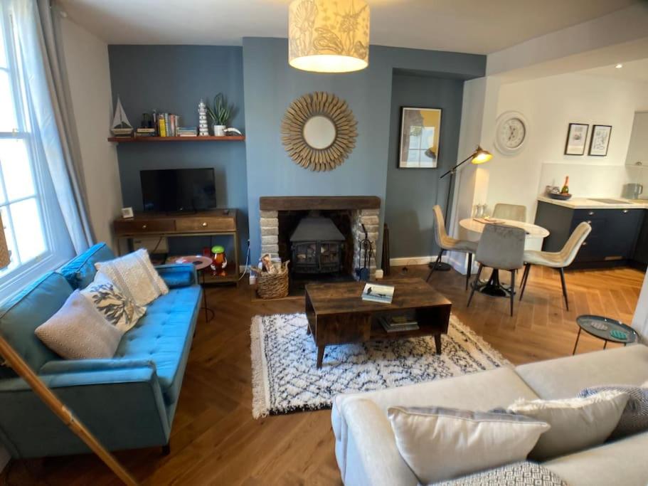斯卡伯勒Cosy 2 bedroom cottage in Scarborough's Old Town的客厅配有蓝色的沙发和桌子