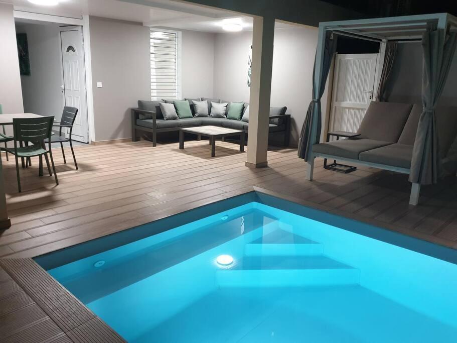 圣玛丽MARS ET VENUS LOCATION - piscine privée et chauffée的客厅,客厅里有一个蓝色的游泳池