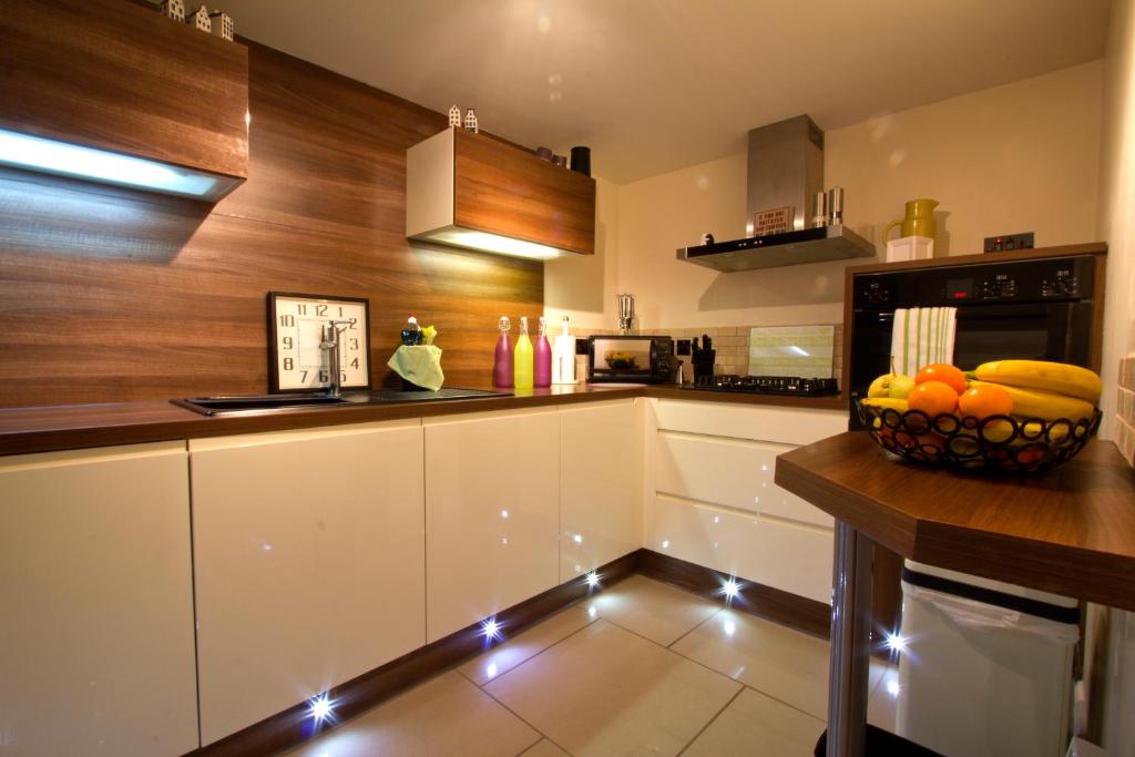 爱丁堡Heritage City - Central New Town Apartment的厨房配有白色橱柜和柜台上的一碗水果