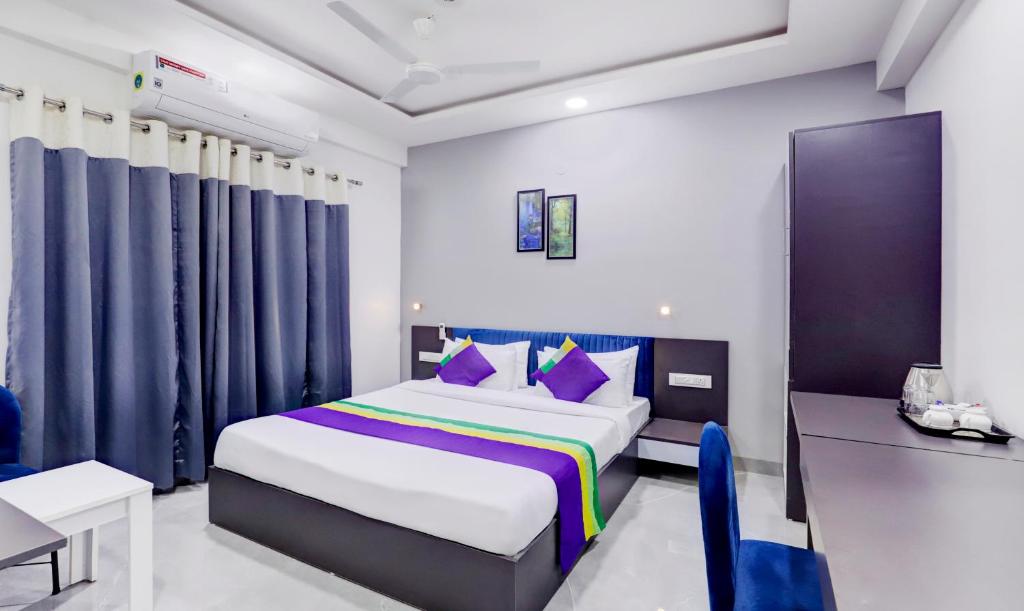 那格浦尔Treebo Trend Finesta Suites, Nagpur Airport的一间卧室配有一张特大号床和一张书桌