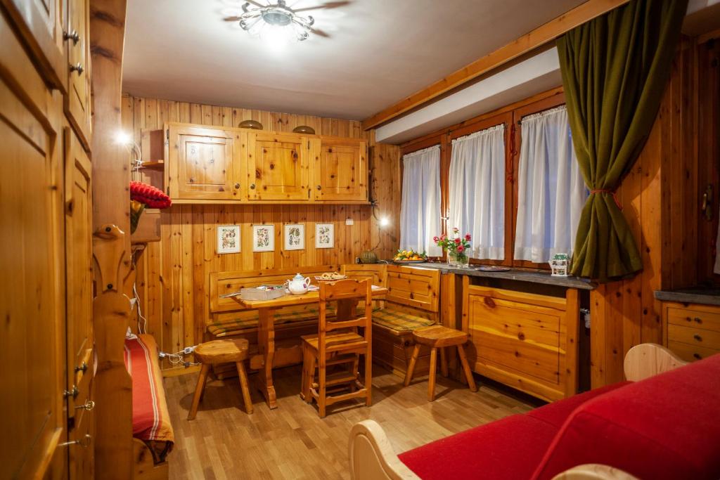 库马约尔Casa-chalet, in centro a Courmayeur!的厨房配有木制橱柜和桌椅