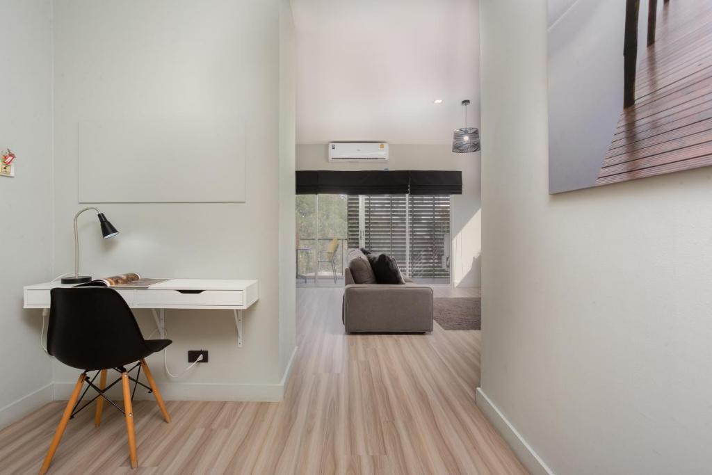 清迈Studio 365 Serviced Apartments的白色的客房配有书桌和椅子