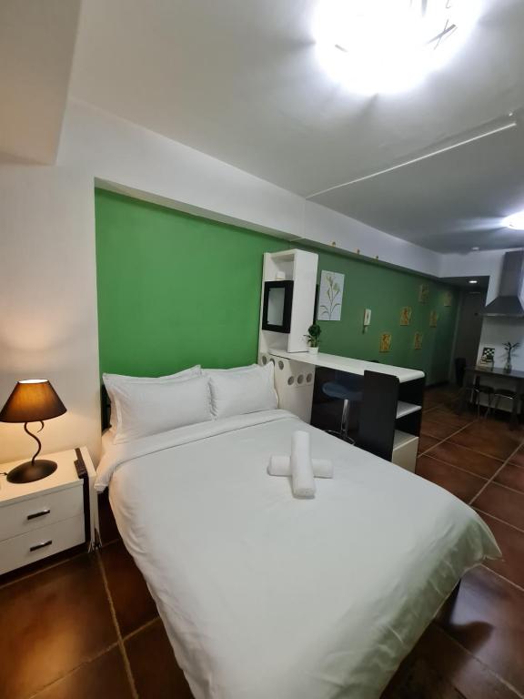 马尼拉Solemare Parksuites Condominium - Condo R Us的卧室配有白色的床和绿色的墙壁