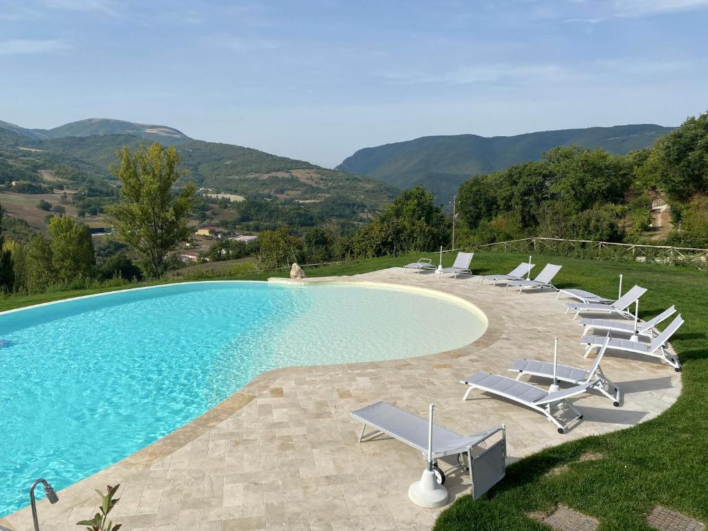 PreciAgriturismo Rocca del Nera的一个带躺椅的游泳池和一个游泳池