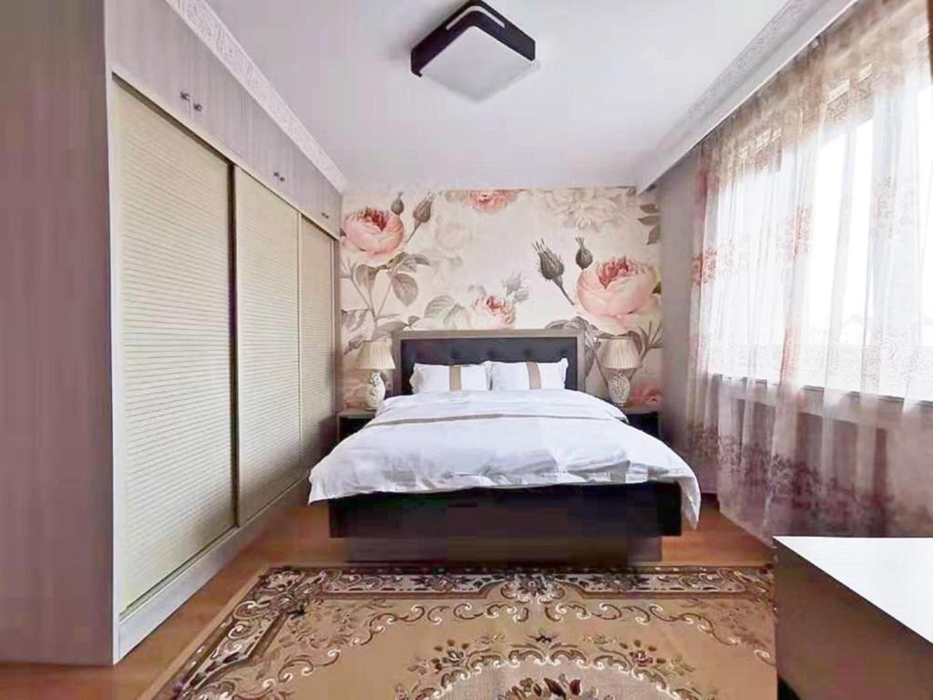 迈松阿尔福La Maison Charentonneau的一间卧室设有一张床和花卉墙